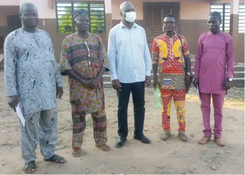 Photo d'ensemble de deux membres du conseil d'administration, de l'équipe avec le Chef d'arrondissement de Challa-Ogoi